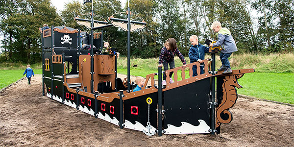 Børn leger på et stort pirat legeskib med masser af legeaktiviteter.